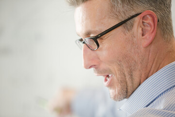 Male teacher leading lesson at whiteboard in classroom