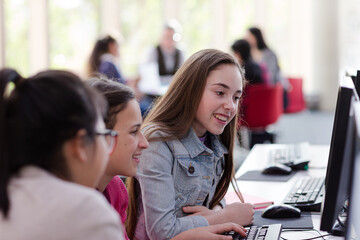 Girl students using computer in library