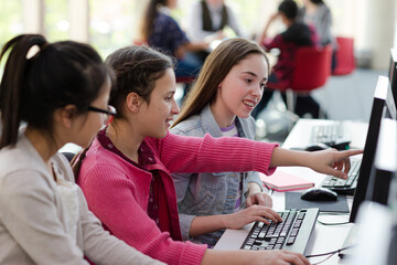 Girl students using computer in library
