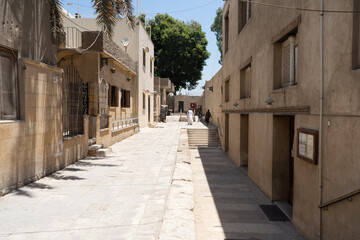 A quiet, urban alley on a bright sunny day in an Arab country. Cairo, Egypt. On the right and left are houses in the Arab style made of sandstone.