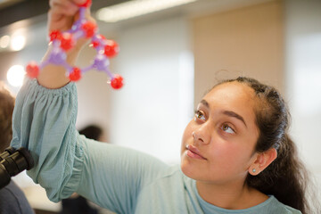 Curious girl student examining molecular structure
