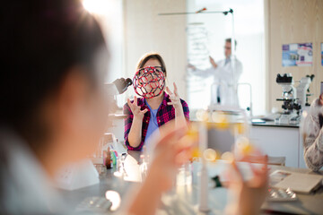 Curious girl student examining molecular structure in classroom