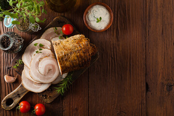 Whole bacon roulade. Served in sliced meat with white sauce. Top view.