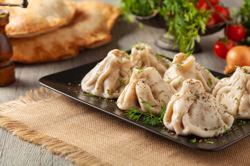 Traditional Georgian dumplings with meat. Khinkali. Served on a plate with traditional Georgian bread.