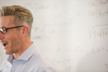 Fototapeta premium Male teacher leading lesson at whiteboard in classroom