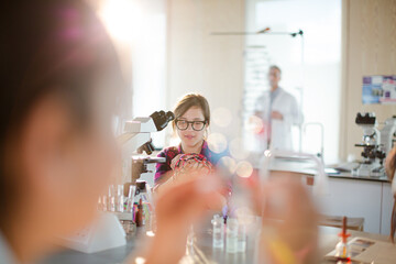 Curious girl student examining molecular structure in classroom