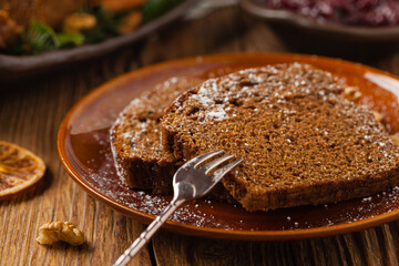 Homemade gingerbread cake. Christmas decoration. Front view. Natural wooden background.