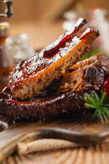 Roasted pork ribs in a bbq sauce. Served on a wooden board. Front view.