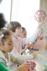 Confident students holding molecular structures in laboratory classroom