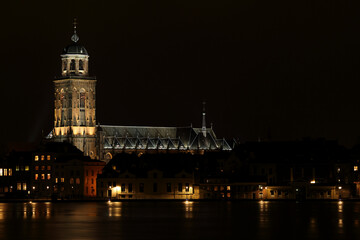 Fototapeta premium The Great Church in the City of Deventer, the Netherlands, at night with reflection in the water