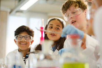 Students examining liquid in test tube, conducting scientific experiment in laboratory classroom