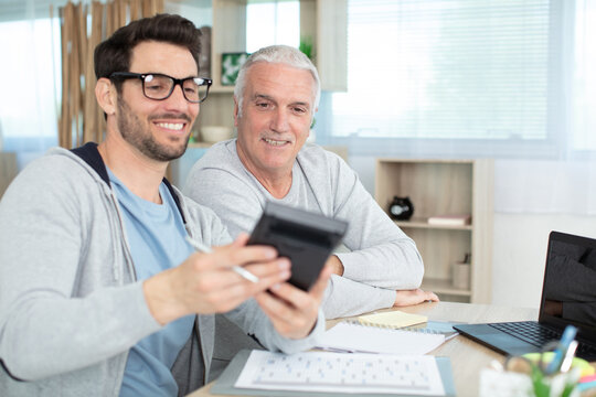 man helping senior neighbor with paperwork