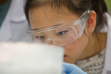 Girl student watching chemical reaction, conducting scientific experiment in laboratory classroom