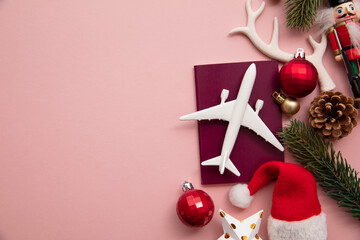 Festive christmas travel background. Airplane with passport and seasonal decorations