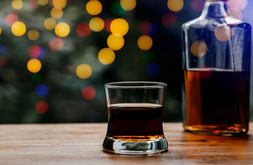 Glass of whiskey and Christmas lights background