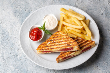 Turkish toast, mixed toast with cheddar cheese, sausage and ham, with fried potatoes (Turkish name; Karisik tost)