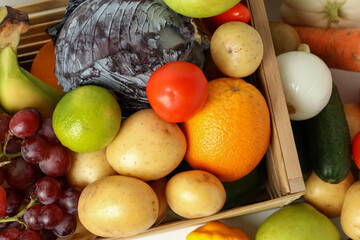 Wooden box with different vegetables and fruits, top view