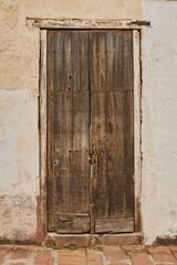 Fototapeta na wymiar Fachada de puerta antigua de madera con desgaste de pintura con espacio de copia