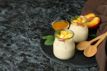 Concept of healthy food with peach yogurt on black smokey table