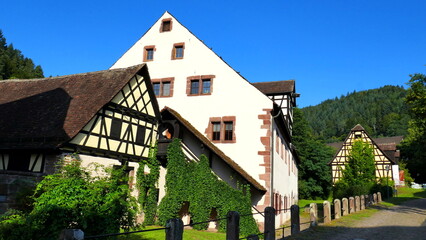 alte Gebäude beim Kloster Hirsau mit Fachwerk und bewachsener Außentreppe unter blauem Himmel