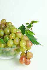 Bowl with green grape on white background, close up
