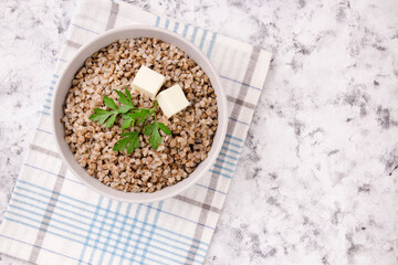 Freshly cooked buckwheat porridge in a plate on a gray background.