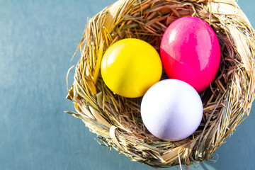 three bright eggs in a basket traditional easter design, red, yellow and white