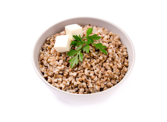Boiled buckwheat in a plate with parsley leaf and butter on a white