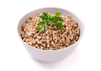 Boiled buckwheat in a plate with parsley leaf and butter on a white
