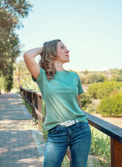 Women wearing t-shirt and jeans stays outdoor in the park