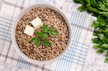 Freshly cooked buckwheat porridge in a plate on a gray background.