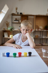 Little boy drawing with gouache, kids in workshop