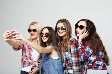 Fototapeta na wymiar four happy teenage girls with smartphone taking selfie