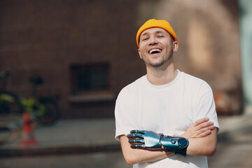 Young disabled laughing man with artificial prosthetic crossed hand portrait
