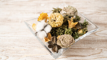 Glass bowl with aroma potpourri on wooden table. Aroma dried petals flowers in a bowl. Naturally fragrant plant