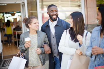 Smiling friends with coffee and shopping bags