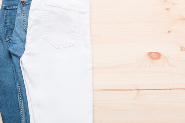 Different types of jeans on a wooden background. Jeans of different colors. Jeans texture.