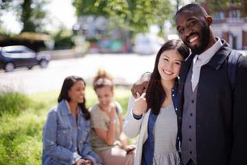 Portrait smiling, affectionate young couple hugging in sunny park