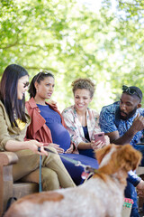 Friends with dog on park bench