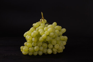 Bouquet of white sweet raisins grapes on a black background