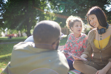 Young friends relaxing in sunny summer park