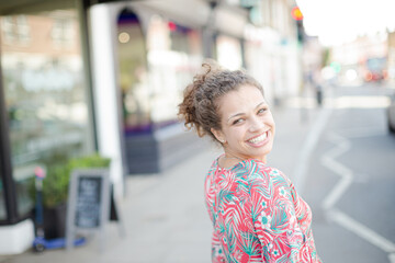 Portrait smiling young woman on urban street