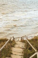 Wooden staircase through the dunes to the Black Sea beach. Minimal, natural tones, natural background.