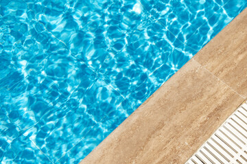 Fototapeta na wymiar Border of swimming pool and blue ripped turquoise water. Summer vacation concept. Banner with copy space