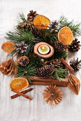 Christmas decoration with a candle and pine cones in wooden box