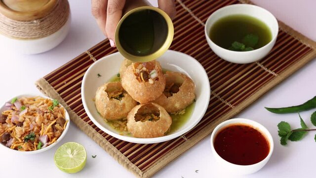 Girl women eating serving Pani puri golgappe with hand Chat item India. North Indian street food Indian panipuri snack 4K footage video tamarind water potato stuffing Delhi Mumbai Holi Diwali Dussehra