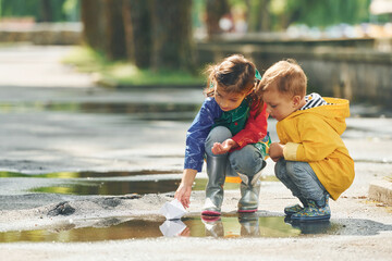 Fototapeta premium In the puddle. Kids having fun outdoors in the park after the rain