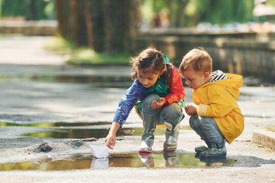 In The Puddle. Kids Having Fun Outdoors In The Park After The Rain