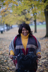 Fototapeta na wymiar Portrait smiling, confident senior woman bike riding in autumn park