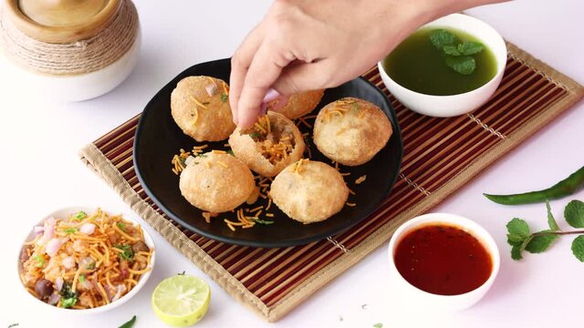 Girl women eating serving Pani puri golgappe with hand Chat item India. North Indian street food Indian panipuri snack 4K footage video tamarind water potato stuffing Delhi Mumbai Holi Diwali Dussehra